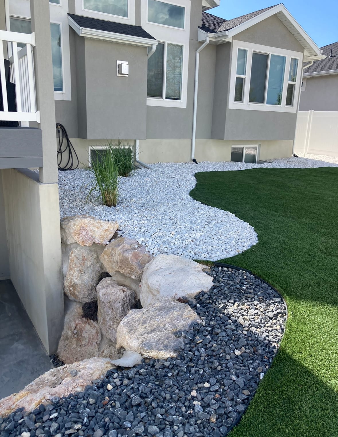 Rock landscaping and artificial turf installed around a Utah home