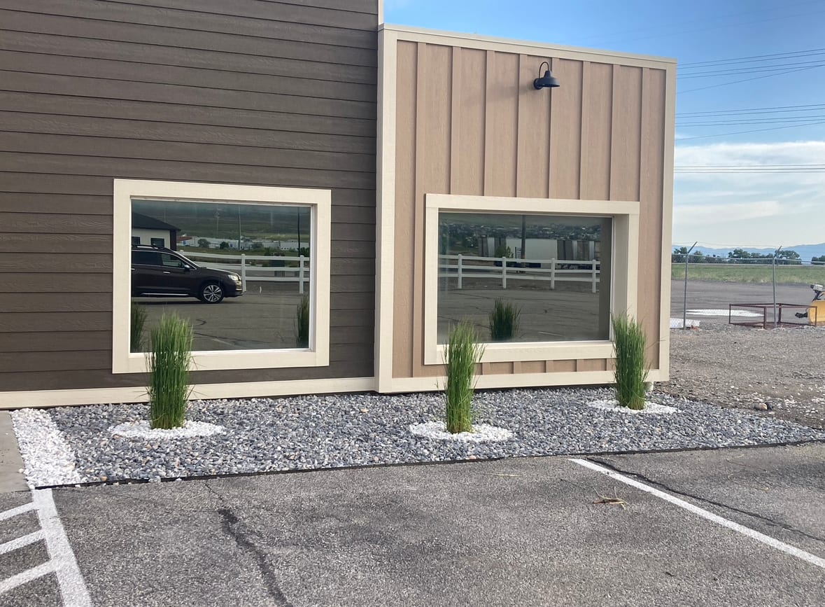 Fresh rock landscaping and upright plants along a building in Syracuse Utah